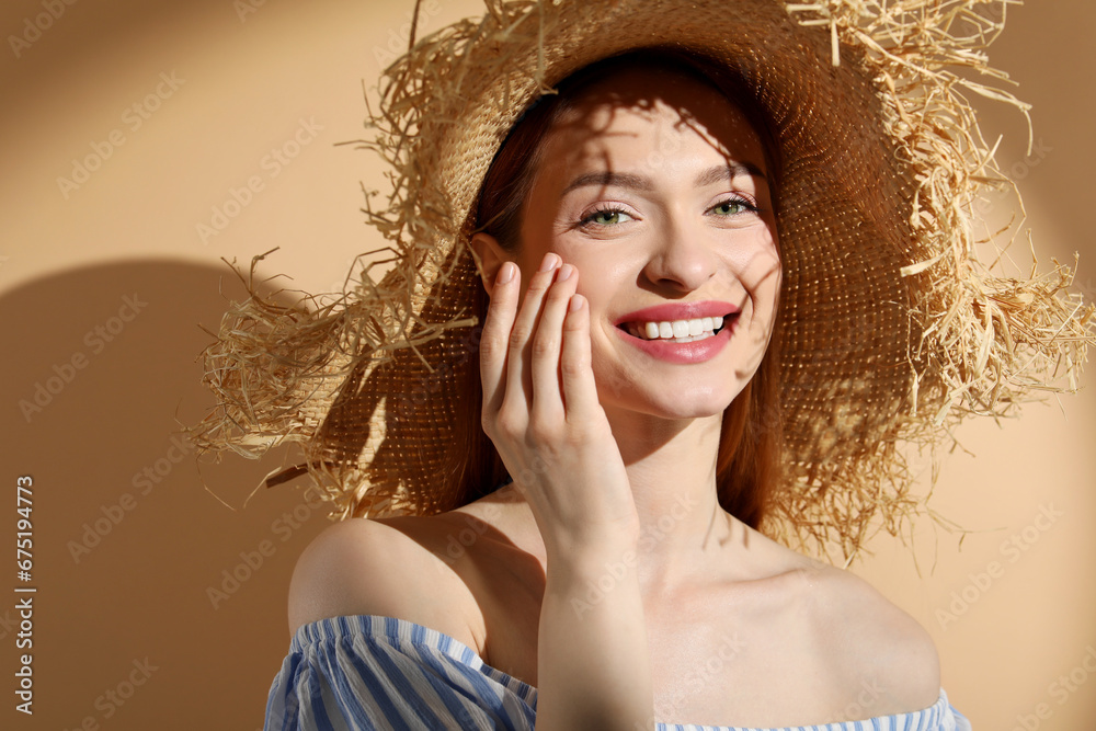 Wall mural beautiful young woman in sunlight on beige background, space for text