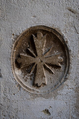 Dettaglio di una croce di Malta scolpita su un palazzo storico di Venezia
