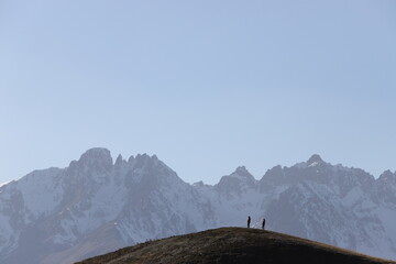 Group of mountaineers climbing a snowy mountain. Beautiful landscape background with silhouettes of...
