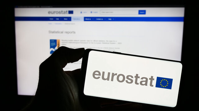 Stuttgart, Germany - 11-02-2023: Person holding mobile phone with logo of EU institution European Statistical Office Eurostat in front of web page. Focus on phone display.