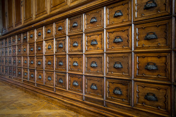 Dettaglio della parete di un archivio in legno con tanti cassetti