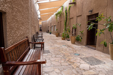 View of narrow clean streets between traditional stone buildings in old city Souk Madinat Jumeirah,...