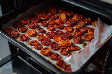 Trays of fresh cherry tomatoes on racks drying in the oven