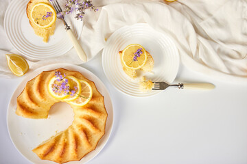 Top view Piece of lemon cake on white table with lavender flower bouquet