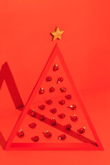 Conceptual Christmas tree with a triangle frame and Christmas balls on red background