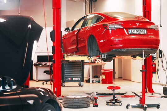Europe, Norway 09.22.2023 Tesla Service Center Drive-In with Tesla Model S lifted. Tesla workshop in Europe.