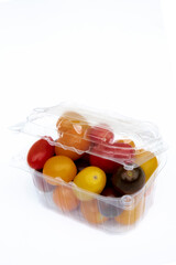 Containers plastic transparency with, Different sorts of tomatoes isolated on white background. Fresh, ripe type of small and round cocktail tomatoes, of red, yellow and orange color.