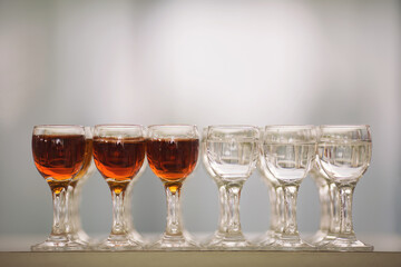 Shots lined up with cognac and vodka. Glasses with alcohol drink closeup.