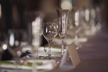 elegant dinner table setting in restaurant or hotel with wine glasses. tableware Glasses, flower fork, knife served for dinner in restaurant