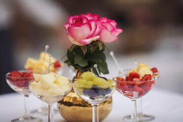 Catering on wedding. Wedding banquet table. Sweet table with fruit. Fruit bar on party. Delicious fruits appetizers, desserts on stand, modern sweet tab.