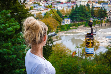 A girl enjoys the picturesque view of the Kutaisi embankment. Selective focus. Georgia