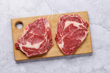 Raw ribeye steaks with savory spices