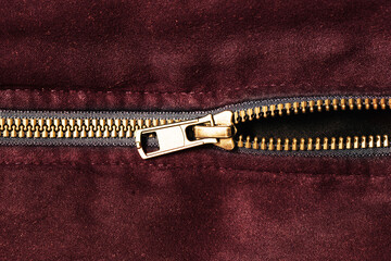 Plastic zipper background. Dark coat zipper. Empty copy space fabric texture. Closeup zipper teeth. Metal shiny clothing part. Closeup zipped zipper. Red suede jacket.