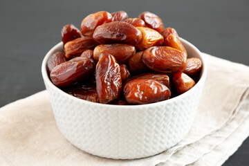 Organic Dry Deglet Nour Dates in a Bowl, side view. Close-up.