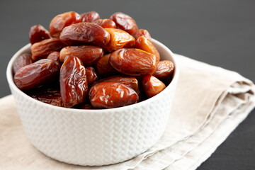 Organic Dry Deglet Nour Dates in a Bowl, side view. Close-up.