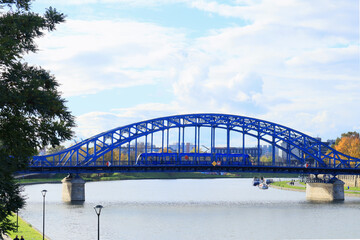 View of the bright blue Józef Piłsudski Bridge on a sunny autumn day - obrazy, fototapety, plakaty