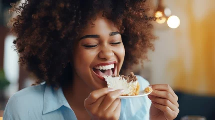 Rolgordijnen Young beautiful african woman eating a cake with cream closeup © Svetlana