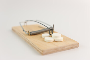 A trap in a mousetrap in the form of medicine. The concept of drug addiction.