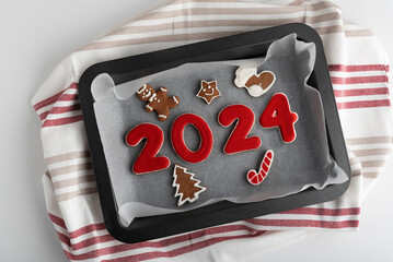 Set of numbers 2024 from ginger biscuits glazed sugar icing on baking sheet