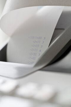 Close up of a cash register with receipt coming out of it
