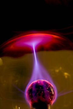 Plasma ball with red purple and pink electrical discharge

