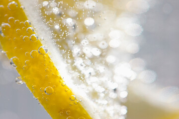 Extreme close up of a slice of lemon floating in sparkling water
