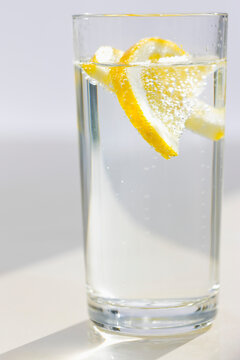Close up of a glass of sparkling water and sliced lemon
