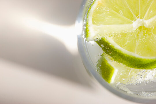 Extreme close up of a glass of sparkling water with sliced lime
