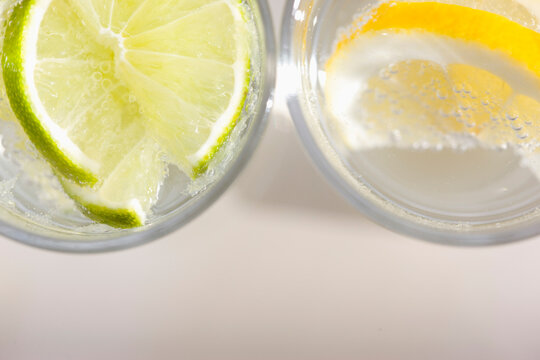 Extreme close up of two glasses of sparkling water with lemon and lime

