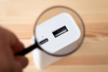 Magnifying glass on USB A port of power bank. Using powerbank for charging concept