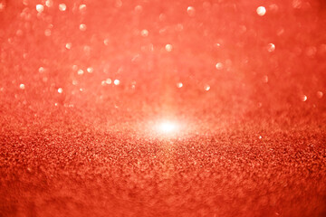 Shining sparkling red blurred background for holiday design. Christmas abstract sparkles, selective focus