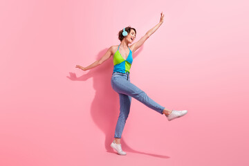 Fototapeta na wymiar Full length photo of charming woman walking dance listen favorite playlist wifi headphones connection isolated on pink color background