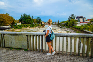 A girl enjoys the picturesque view of the Kutaisi embankment.  Georgia