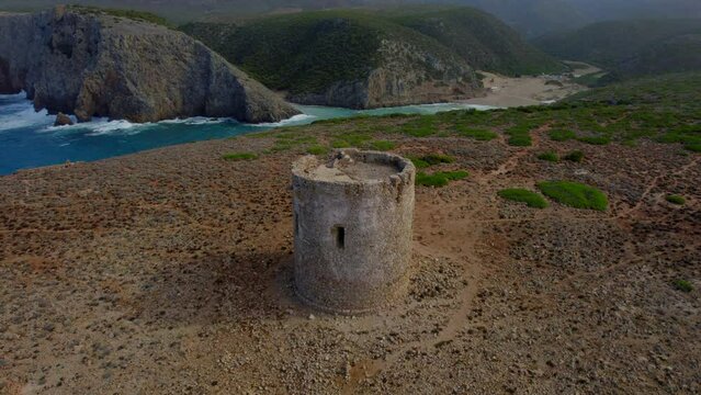 Fantastic aerial view in a circle over the Torre di Cala Domestica and its beautiful nearby beach of the same name.
