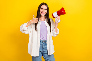 Photo of cheerful pretty woman with brunette hair dressed white jacket hold megaphone show thumb up isolated on yellow color background