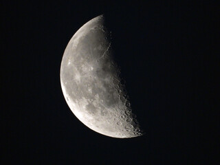 moon in the third quarter phase with dark sky in the background