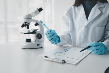 Fototapeta premium Chemist taking notes on research data, Scientist is working in the laboratory, Chemist is analyzing experimental results and taking notes in the laboratory, lab idea.