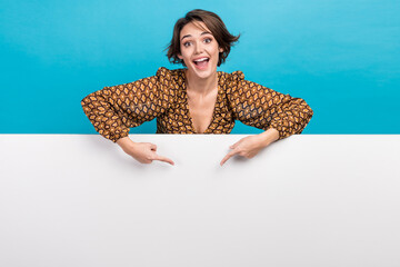 Photo of astonished person indicate fingers empty space advert proposition placard isolated on blue color background © deagreez