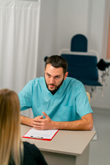 Fototapeta premium An experienced doctor consults young girl in his medical office and carefully examines her tests