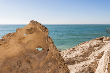 Fototapeta na wymiar Beautiful piece of rock on the shore of the Caspian Sea. Stone with a hole on the seashore.