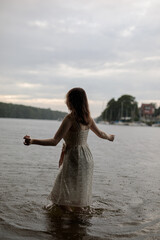 Fototapeta na wymiar young shy cosplay woman in dress on an rainy day on sea