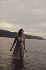 Fototapeta na wymiar young shy cosplay woman in dress on an rainy day on sea