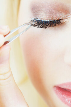 Extreme close up of Woman Applying False Eyelashes
