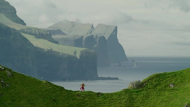 Single woman walking on a coast on Faroe Island