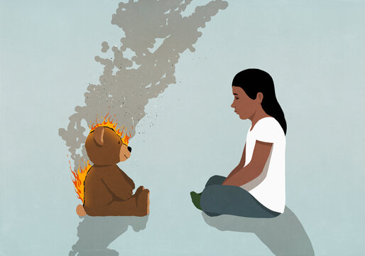 Girl watching teddy bear on fire burning

