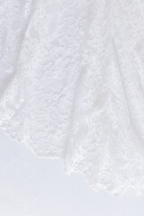Chic white wedding background. Soft pleats of lace vintage fabric. Floral ornament. Vertical view. A copy of the space. Design mockup.