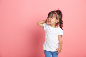 Curious little girl keeps hand near ear for eavesdropping likes gossip, wants to overhear secret information, wearing in white t shirt, tries to hear parents conversation. - obrazy, fototapety, plakaty