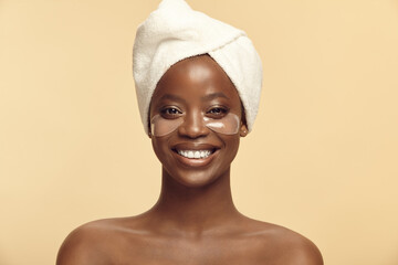 African American girl smiling, having under eye mask with patches.