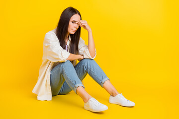 Full size profile portrait of disappointed desperate girl sit floor empty space isolated on yellow...