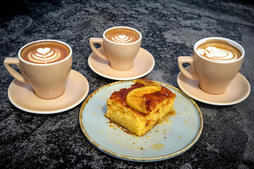 Three cups of cappuccino and cake close-up. Perfect for coffee shop and dessert-themed 